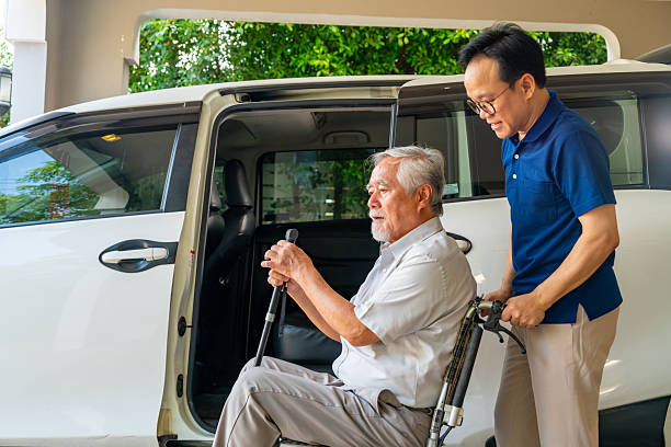 istock Caregiver helping senior man get in the car. 2205778005