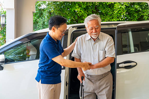 istock Caregiver helping senior man get in the car. 2205778007