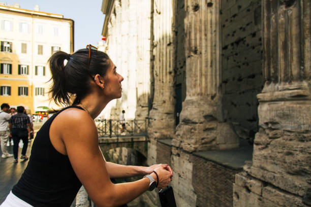 istock Woman Observing Ancient Roman Columns While Exploring Historic Architecture 2205783378