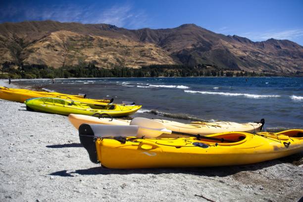 istock Colorful Kayaks on a Serene Lake Beach in NZ 2205784622