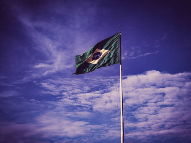 Brazilian flag hoisted on color effect background.