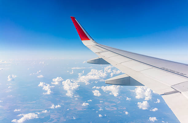 istock View from the airplane window at a beautiful cloudy sky and the airplane wing 2205800277
