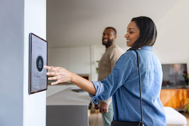 istock Couple leaving their house and locking the door using an automation system 2205801168