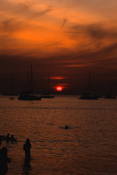 istock A Stunning and Beautiful Sunset Over the Calm Water Featuring Silhouetted Figures 2205811818