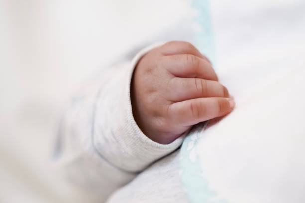 istock Close-up of a baby's hand on a soft blanket. 2205812412