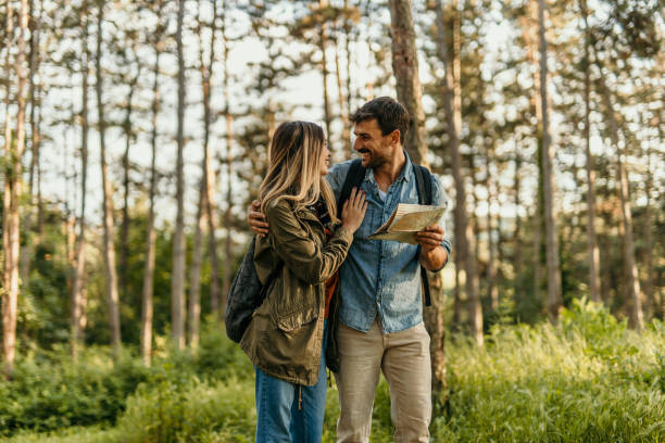 istock Young couple hiking and reading a map in the forest 2205814358