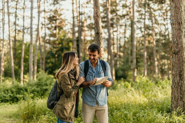 istock Happy couple hiking and looking at map in forest 2205814359