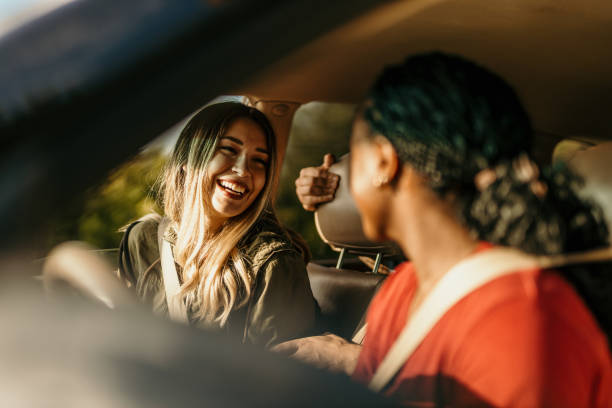 istock Two young women laughing and talking during a car trip 2205814423