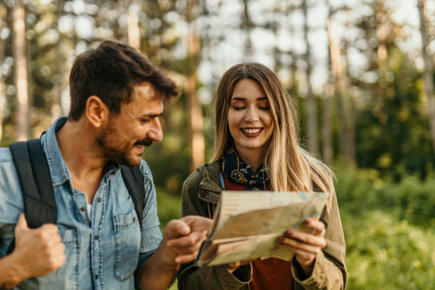 istock Happy couple hiking with a map in forest 2205814671