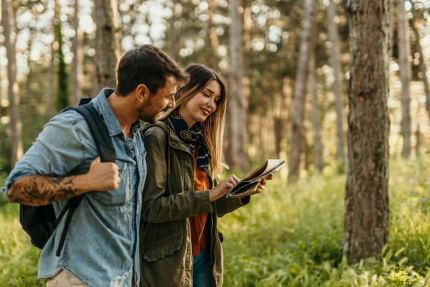 istock Happy couple hiking with a map in forest 2205814673