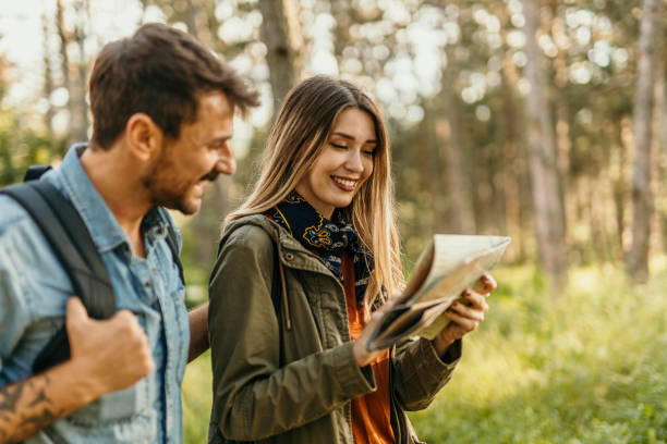 istock Happy couple hiking with a map in forest 2205814676
