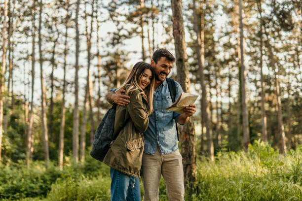 istock Happy couple hiking with a map in forest 2205814684
