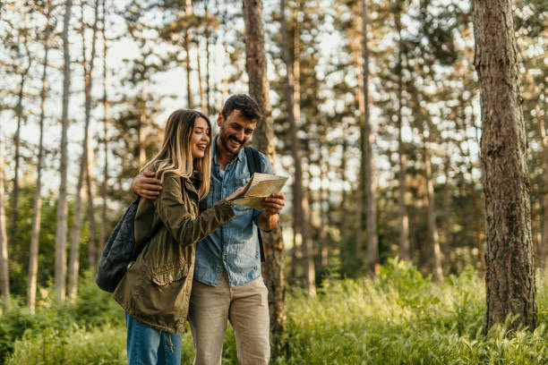 istock Happy couple hiking and looking at map in forest 2205815020