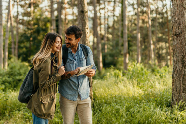 istock Happy couple hiking and looking at map in forest 2205815103