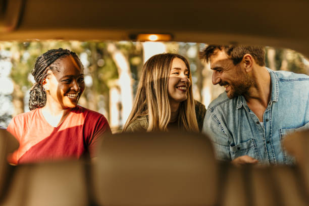 istock Happy friends laughing while unpacking their car during a camping trip 2205815121