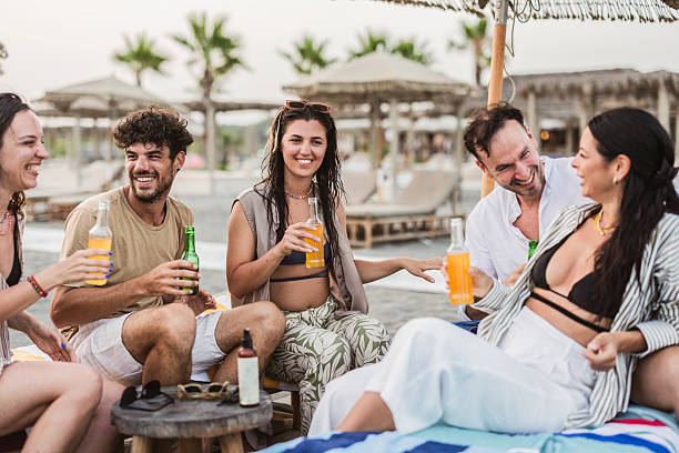 istock Friends enjoying drinks and laughter on the beach 2205816735