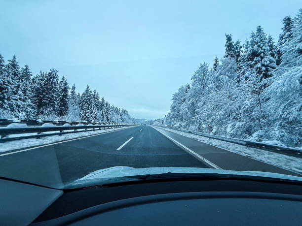 istock Driving on a Snowy Winter Highway Through a Frozen Forest 2205816812
