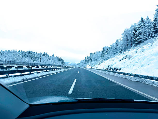 istock Driving on a Snowy Highway Through Winter Forest Landscape 2205816815