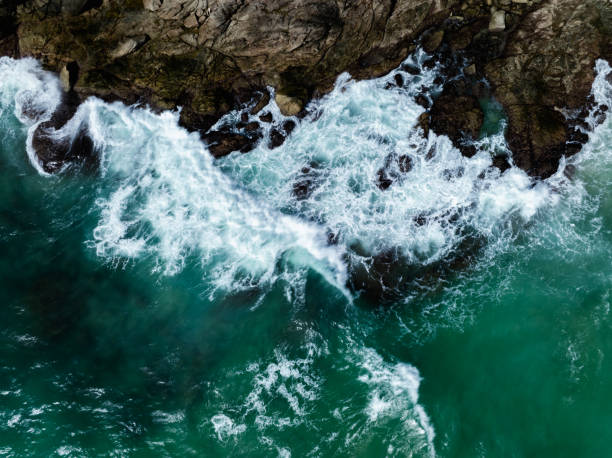 istock beautiful sea waves hiting rocks, aerial top view 2205817172