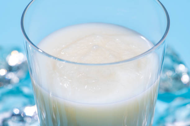 Close-up of a vanilla shake on ice with a light blue background