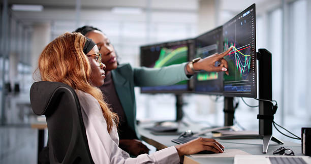istock Analyzing stock market data, businesswoman views multiple screens 2205819126