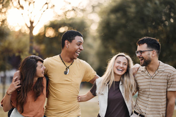 istock Cheerful friends talking while walking embraced in nature. 2205820434