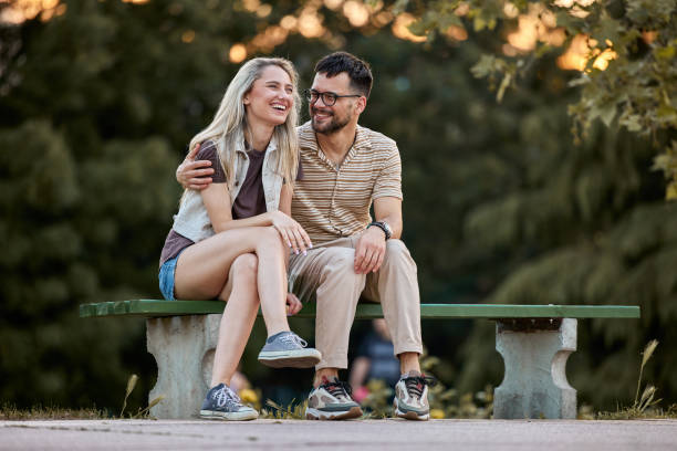 istock Cheerful couple relaxing on a park bench in nature. 2205820494