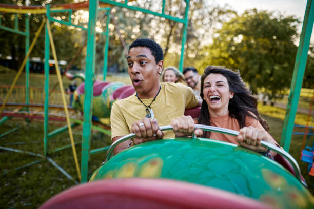 istock Happy couple having fun while riding on rollercoaster at amusement park. 2205820736