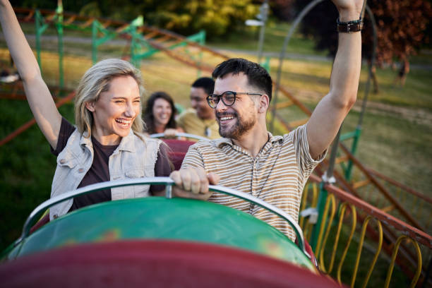 istock Young happy couple having fun on rollercoaster at amusement park. 2205821659