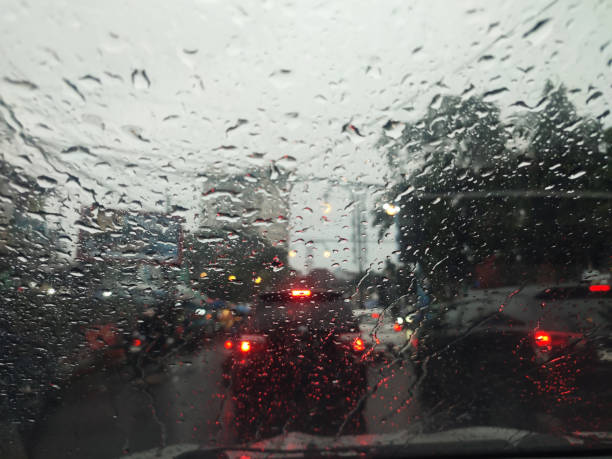 istock Road view through car window with rain drops  Driving in rain. 2205822008