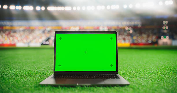 istock Laptop Computer with a Green Screen Mock Up Display on a Soccer Stadium Field at Night. Template for Software, Streaming, Betting, Multimedia Content and Social Media Management 2205822776