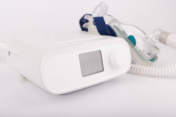 istock Sleep apnea therapy CPAP machine with hose and full-face mask on white background 2205823397