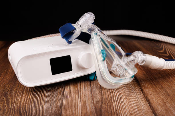 istock White CPAP Machine with Display and Mask for Sleep Apnea Therapy on Dark Wooden Table 2205824165