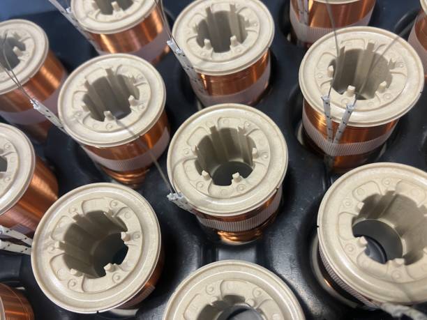 Close-up of industrial copper wire coils, meticulously wound around cylindrical cores. The image showcases precision engineering, electrical conductivity, and manufacturing aesthetics in modern technology and power applications. High quality photo primer plano de bobinas de alambre de cobre industrial, meticulosamente enrolladas alrededor de núcleos cilíndricos. la imagen muestra la ingeniería de precisión, la conductividad eléctrica y la estética de fabricación en aplicaciones modernas de te