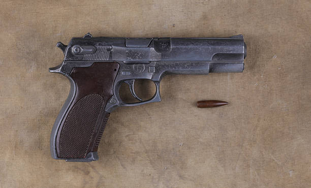 istock military pistol on military fabric 2205825278