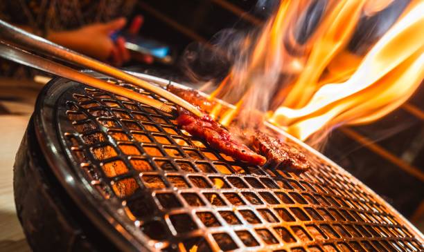 istock Sizzling meat on a barbecue grill with flames. 2205827304