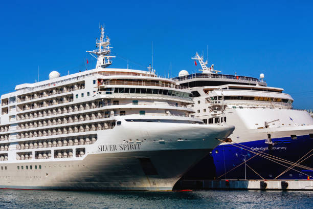 Two luxurious cruise ships docked at a port under a clear blue sky, with the names Silver Spirit and Celestial Journey visible. Kusadasi, Aydin, Turkey (Turkiye). Oct 19, 2023