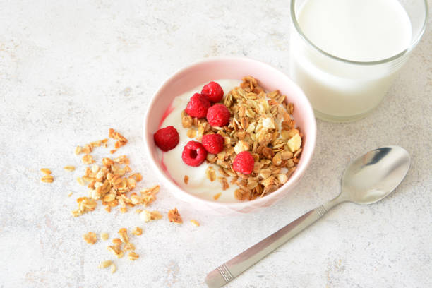 istock Granola Yogurt Breakfast with Raspberries and Milk and spoon flat lay 2205832453