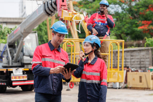 istock A group of technicians, wearing safety helmets and work uniforms, are gathered at a construction site, discussing plans and strategies 2205836792