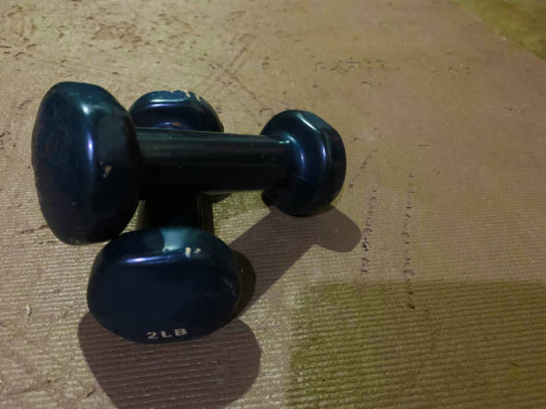 istock 2 pound dark blue dumbbells lay flat on yoga mat 2205840818