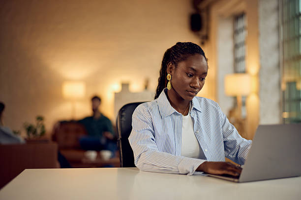 istock Focused Woman Working on a Laptop in a Modern Creative Co-Working Space 2205842377