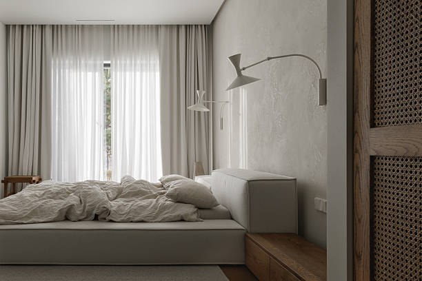 wabi-sabi bedroom features an oak bedside table, textured clay wall decor, soft linen bed linens, a neutral grey rug, and a woven rattan wardrobe, creating a harmonious blend of natural materials and serene style.
