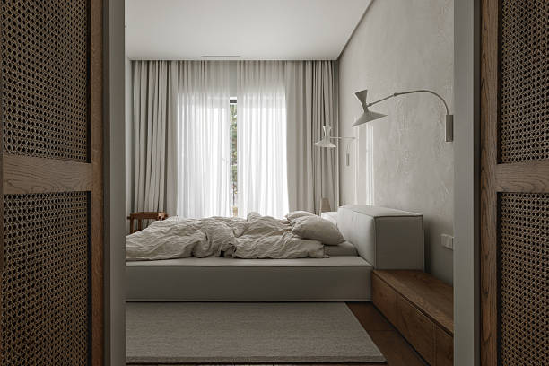 istock wabi-sabi bedroom features an oak bedside table, textured clay wall decor, soft linen bed linens, a neutral grey rug, and a woven rattan wardrobe, creating a harmonious blend of natural materials and serene style. 2205842446