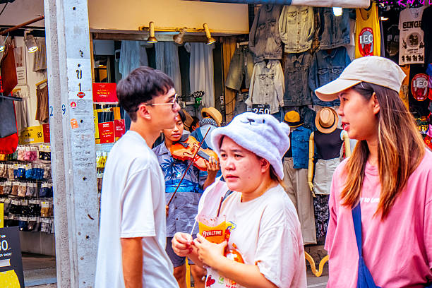 Tourists wandering through the vibrant Chatuchak Market in Bangkok, exploring unique goods, local crafts, and the lively atmosphere of the market.