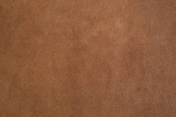 Genuine leather suede skin, textured surface, brown close up parchment structure , abstract backdrop