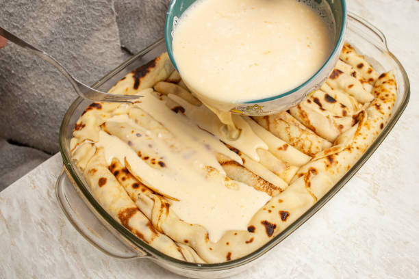 istock Pouring sour cream sauce on a cheese  pancake pie , preparation process 2205846522