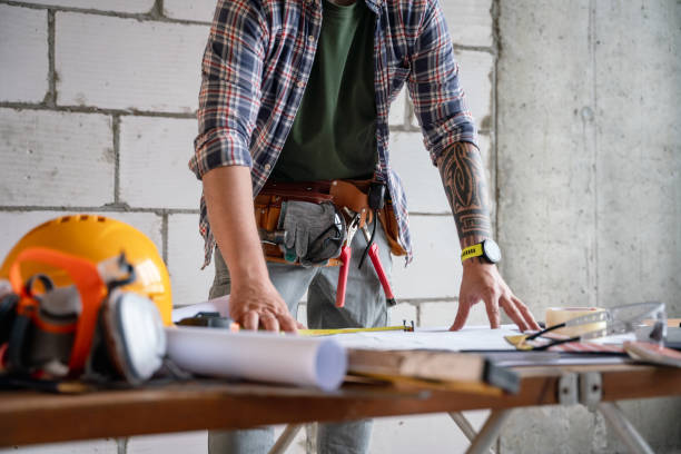istock Construction Worker Reviewing Blueprint Plans at Job Site Workspace 2205848797