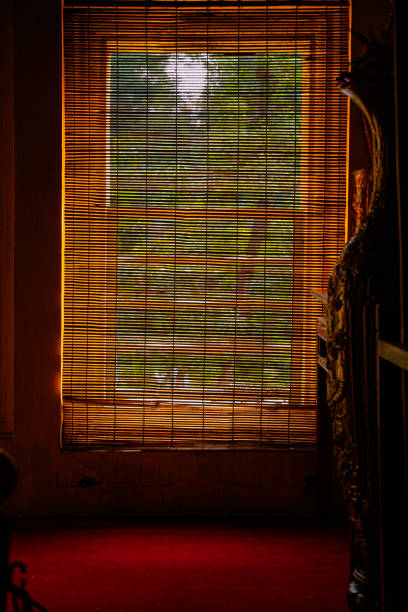 istock Dimly lit Vietnamese room with wooden window blinds 2205849897