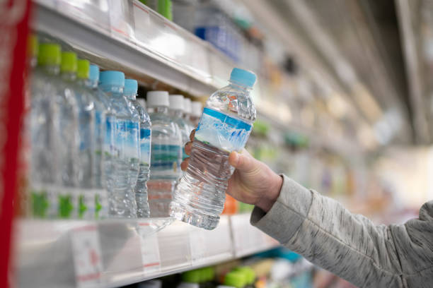istock Shopper's hands buying bottled water 2205851687
