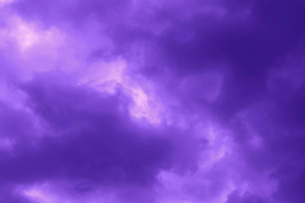 Purple dramatic stormy sky background. Dark fluffy cloudy sky. Halloween spooky moody scary cloudscape background concept.